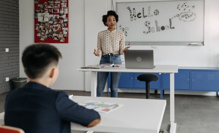 A teacher standing in front of a whiteboard leading a lesson